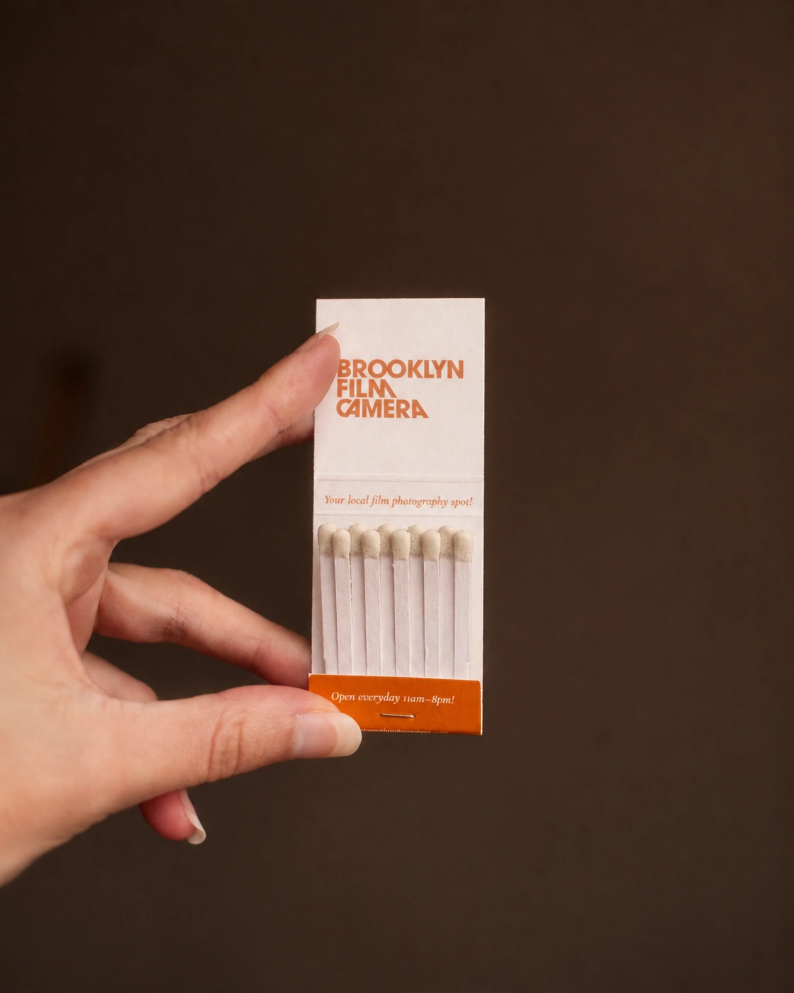 An open Brooklyn Film Camera matchbook with orange typography