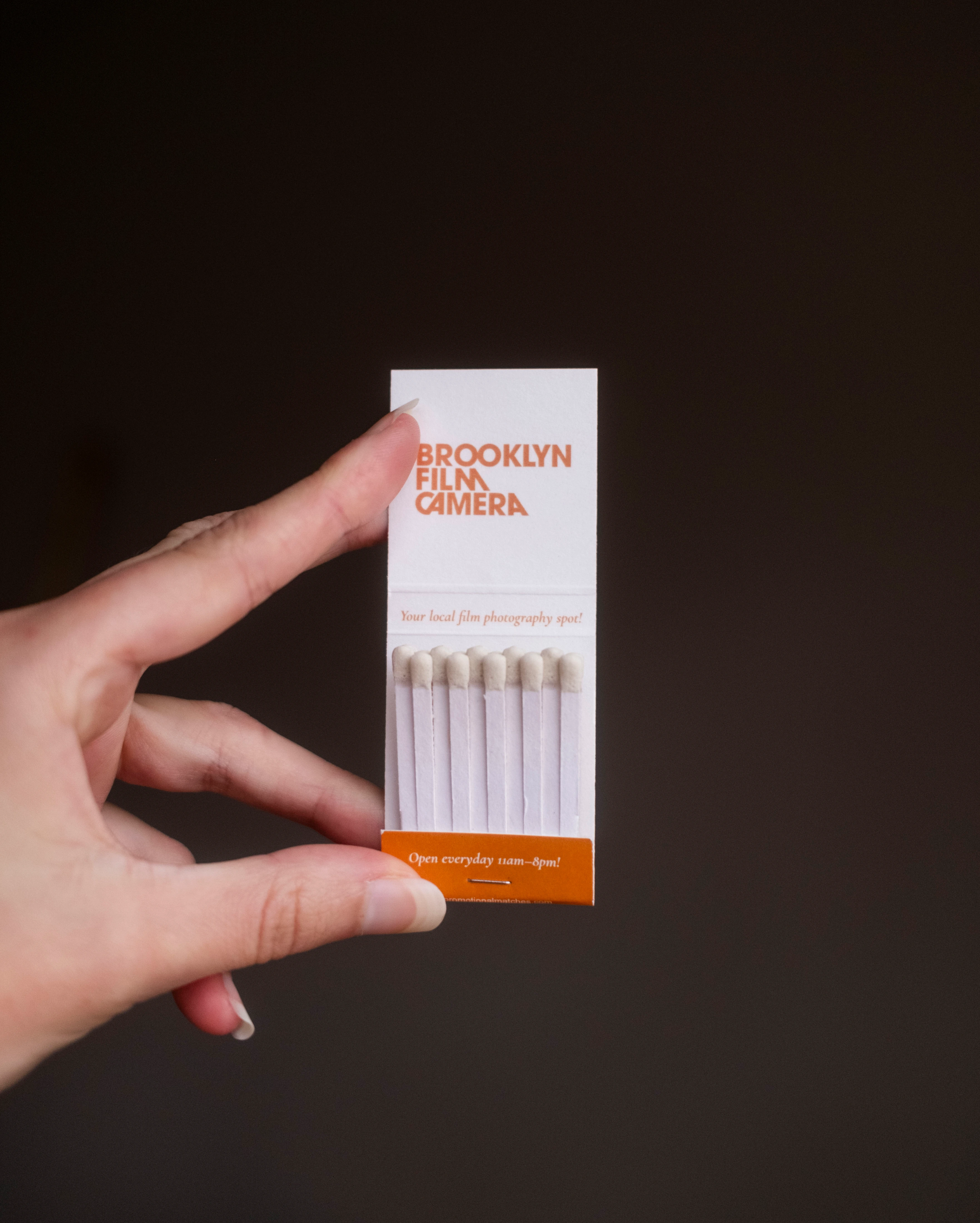 An open Brooklyn Film Camera matchbook with orange typography