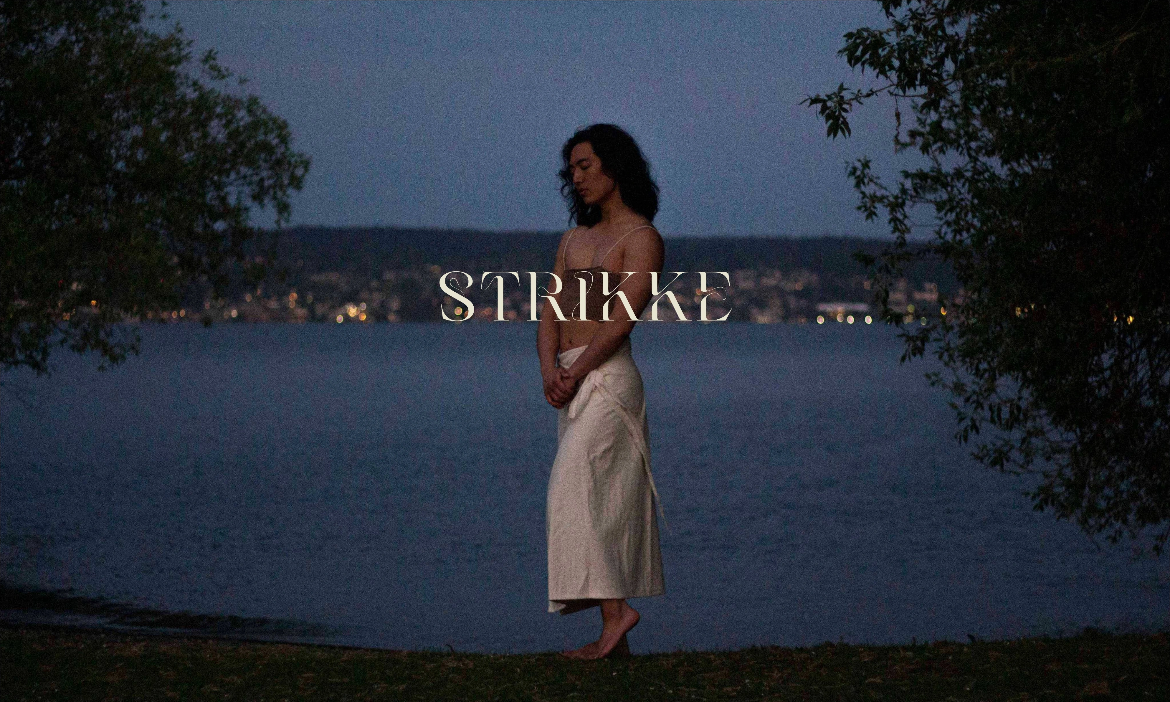 Strikke website identity over a photograph of knitwear beside a lake